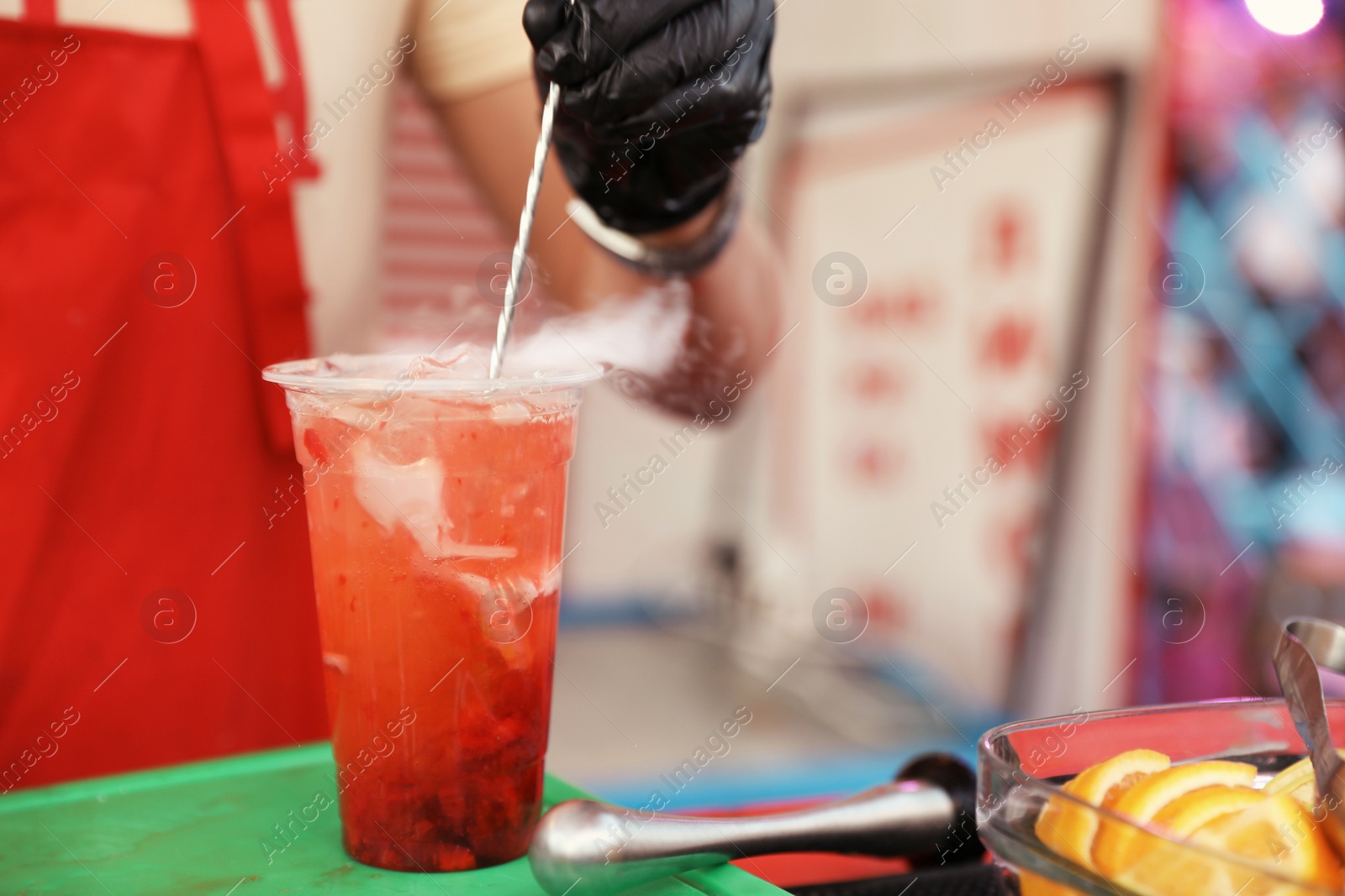 Photo of Male bartender preparing refreshing drink at table, closeup