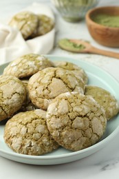 Plate with tasty matcha cookies on white table, closeup