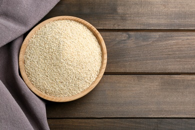 Photo of Sesame seeds on wooden table, top view. Space for text