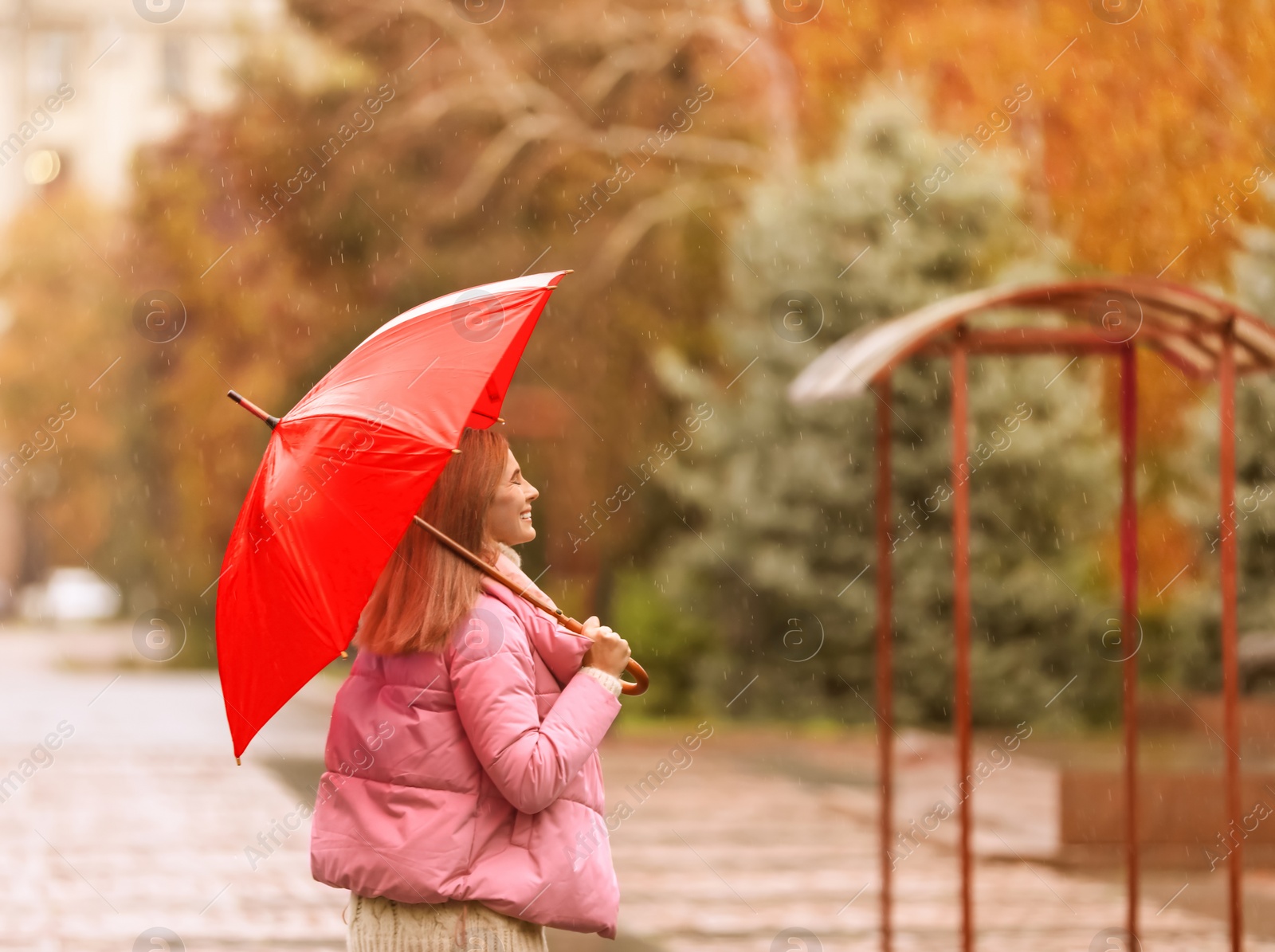 Photo of Woman with umbrella in city on autumn rainy day