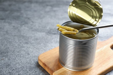 Canned green beans on grey table, closeup. Space for text