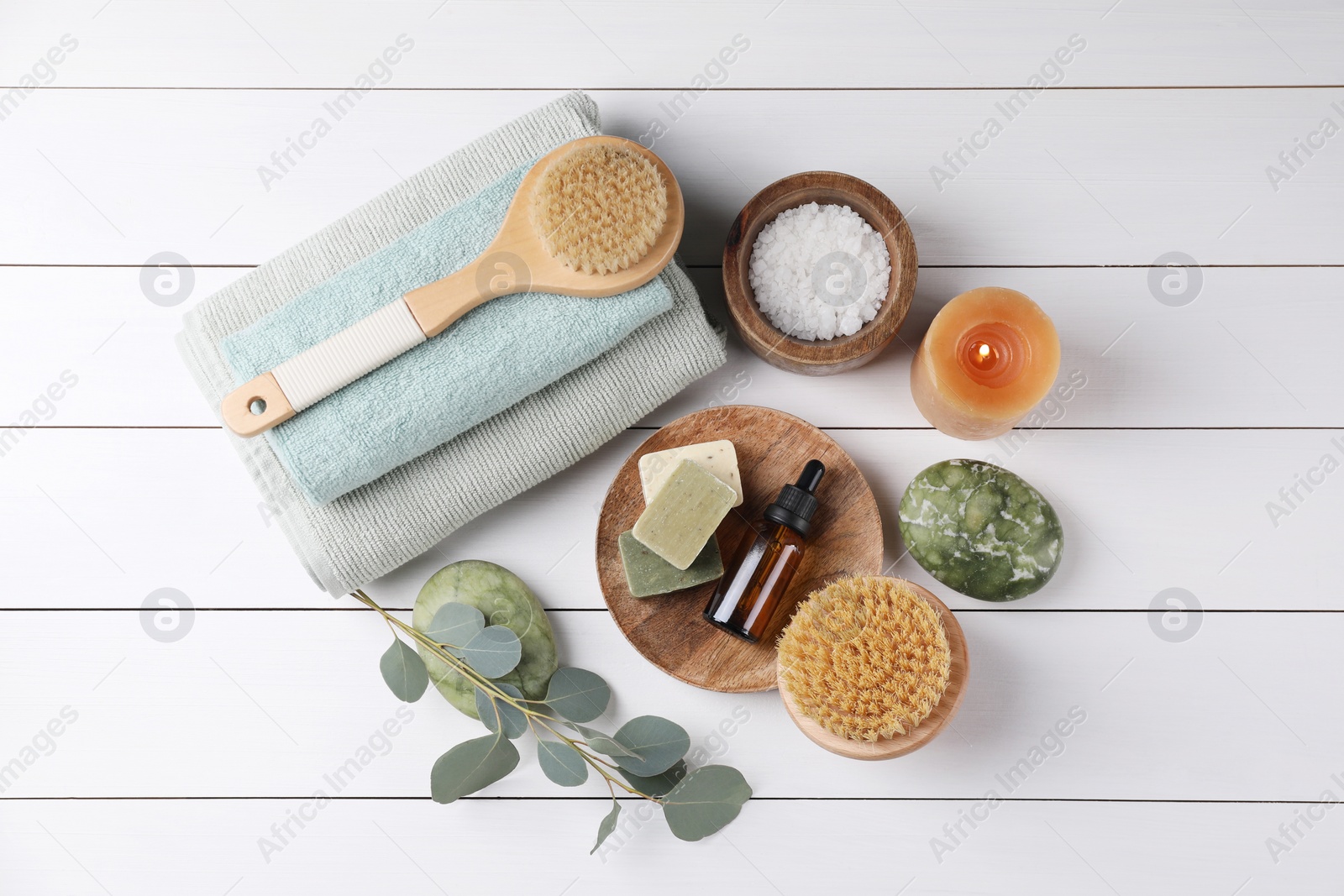 Photo of Flat lay composition with different spa products and burning candle on white wooden table