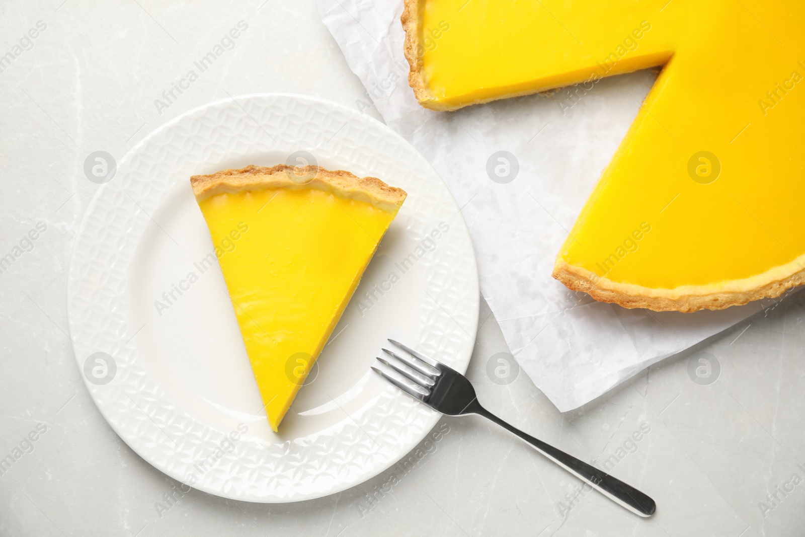 Photo of Delicious homemade lemon pie on light grey marble table, flat lay