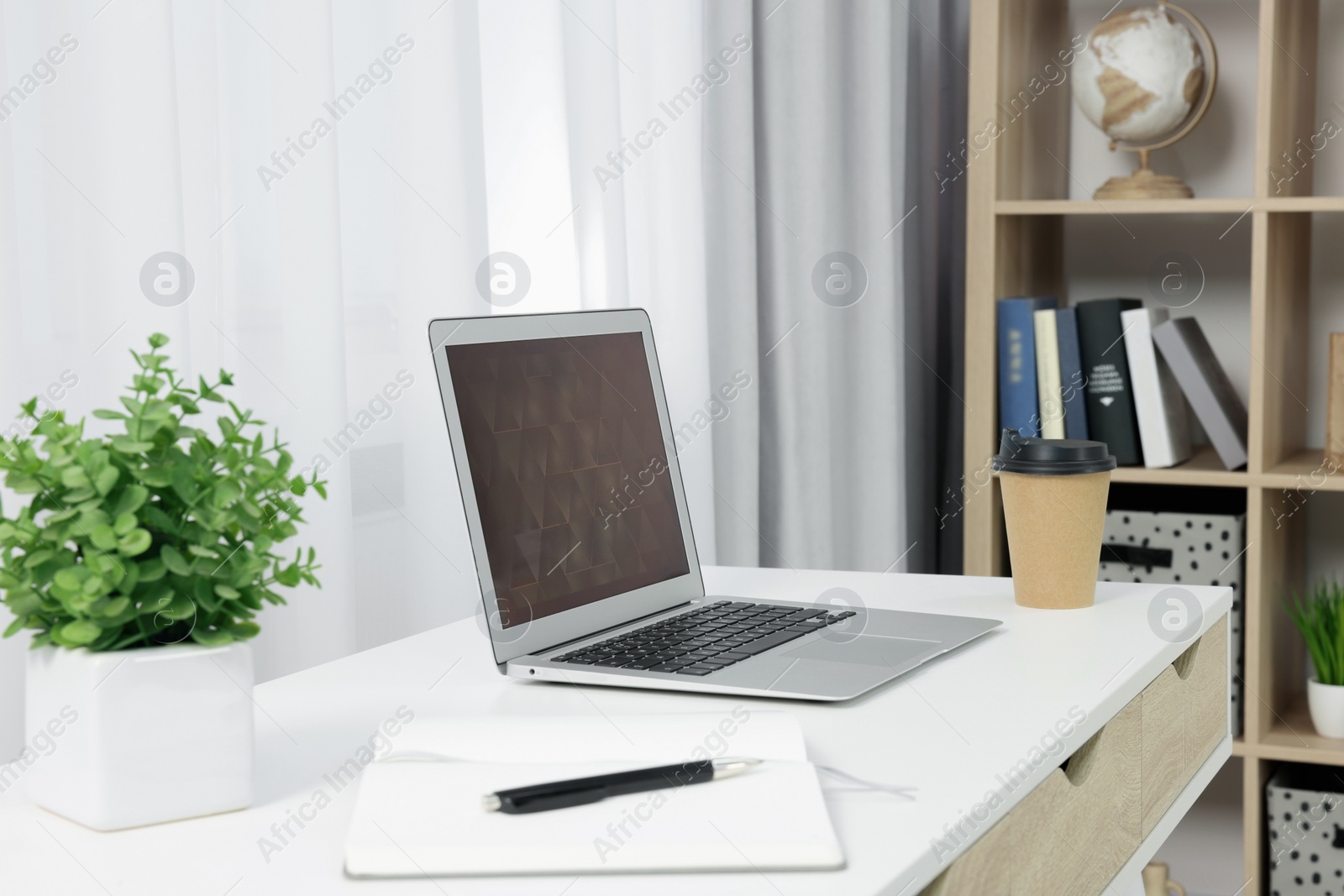 Photo of Workplace with modern laptop on desk at home