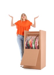 Photo of Young emotional woman near wardrobe box on white background