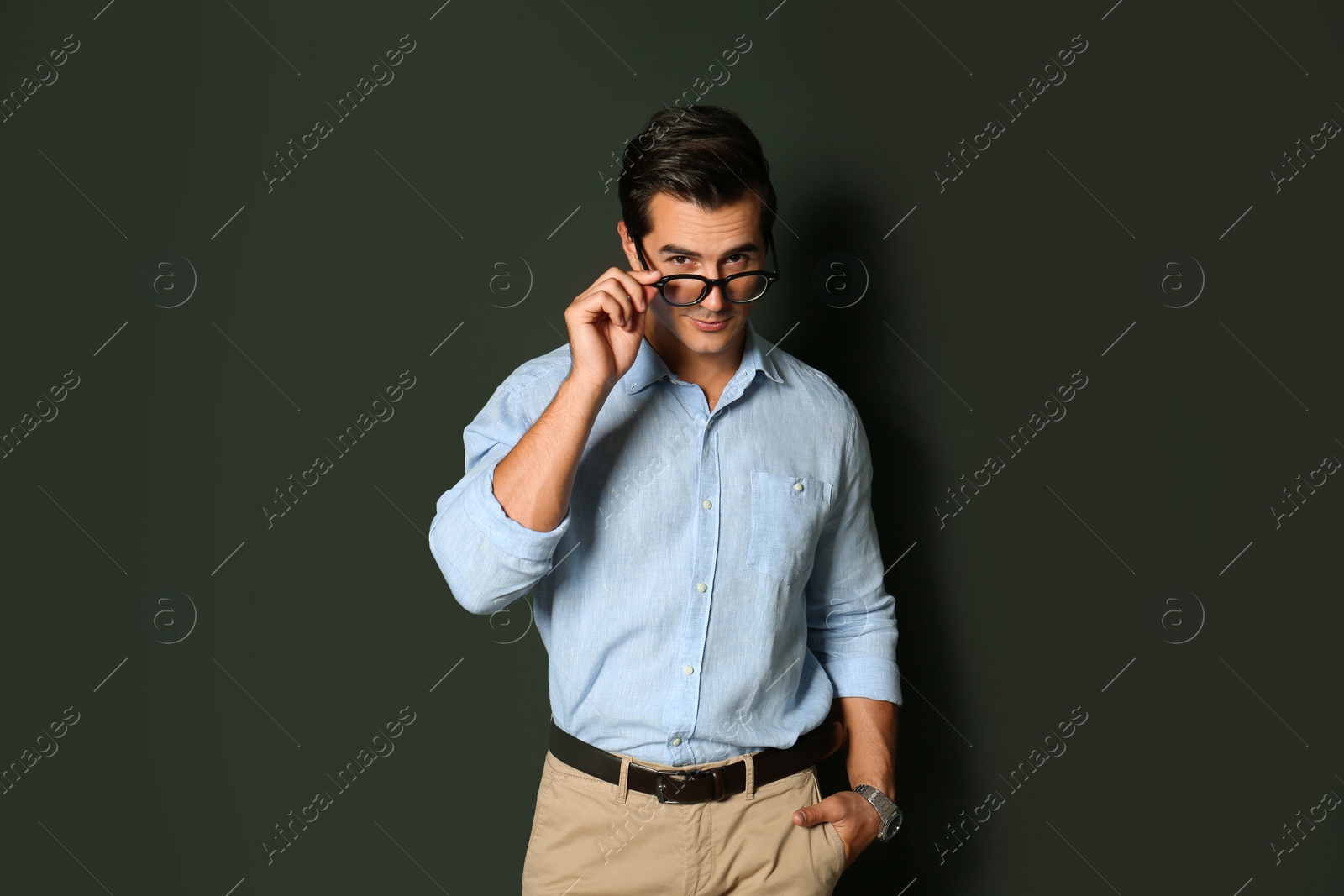 Photo of Handsome young man in stylish clothes with glasses on dark background