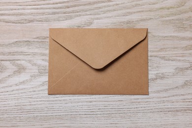 Paper envelope on white wooden table, top view