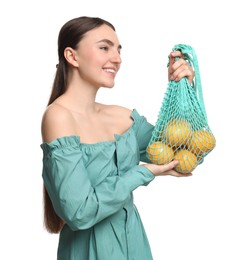 Woman with string bag of fresh lemons on white background