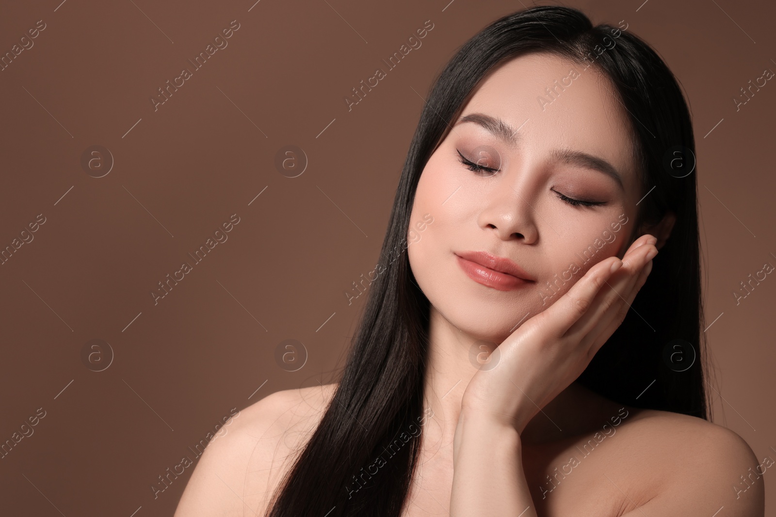 Photo of Portrait of beautiful woman on brown background