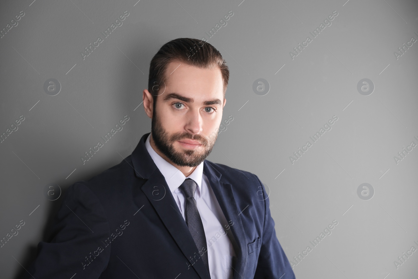 Photo of Portrait of young businessman with beautiful hair on grey background