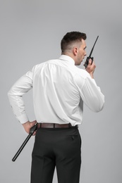 Photo of Male security guard using portable radio transmitter on color background