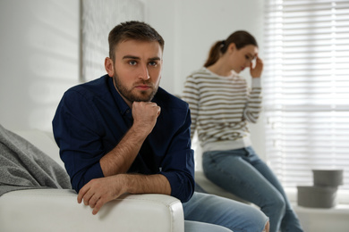 Photo of Young couple quarreling at home. Jealousy in relationship