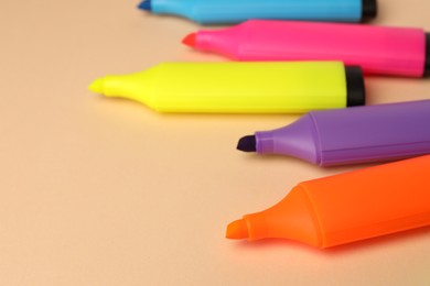 Photo of Bright color markers on beige background, closeup. Space for text