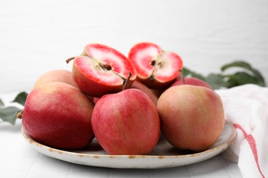 Tasty apples with red pulp on white tiled table
