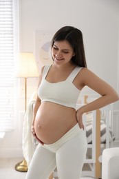 Photo of Happy pregnant woman at home. Choosing baby name
