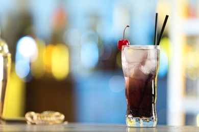 Photo of Fresh alcoholic cocktail with cherry on bar counter, space for text