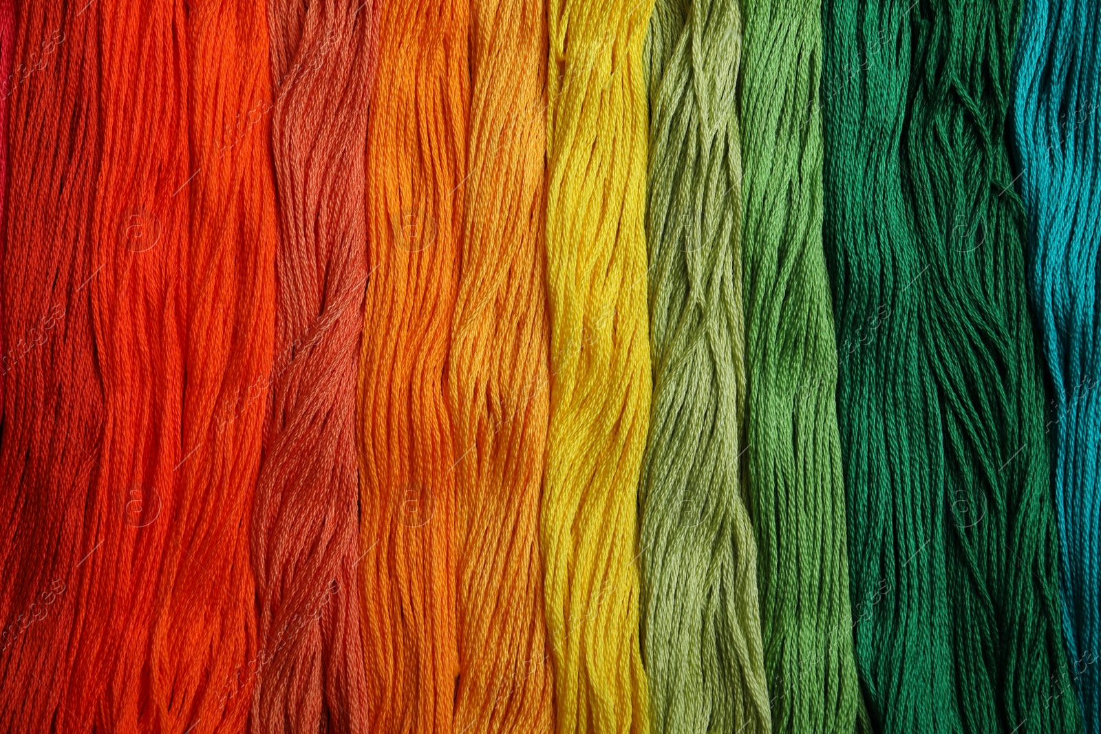 Photo of Different colorful embroidery threads as background, top view