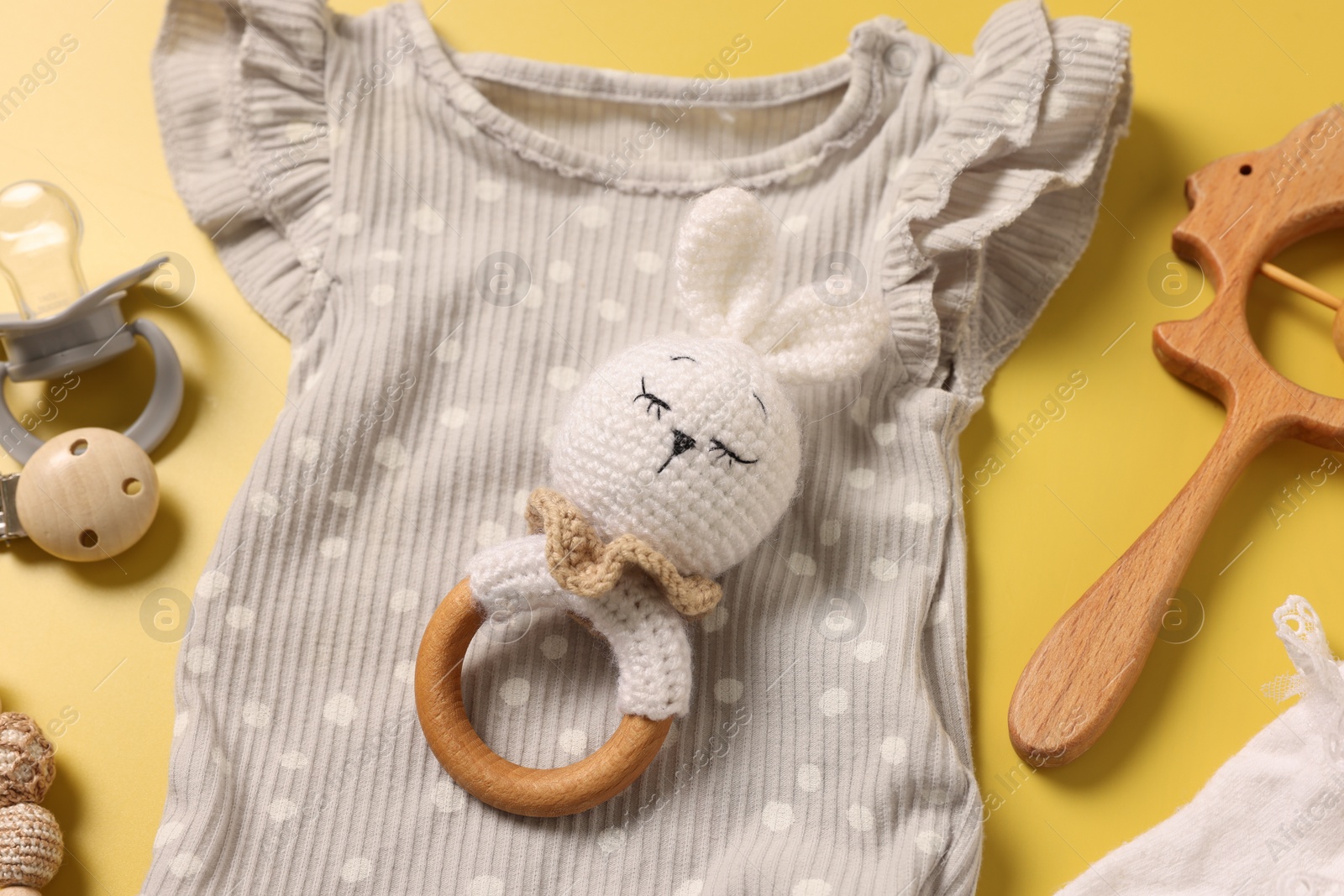 Photo of Different baby accessories on yellow background, above view