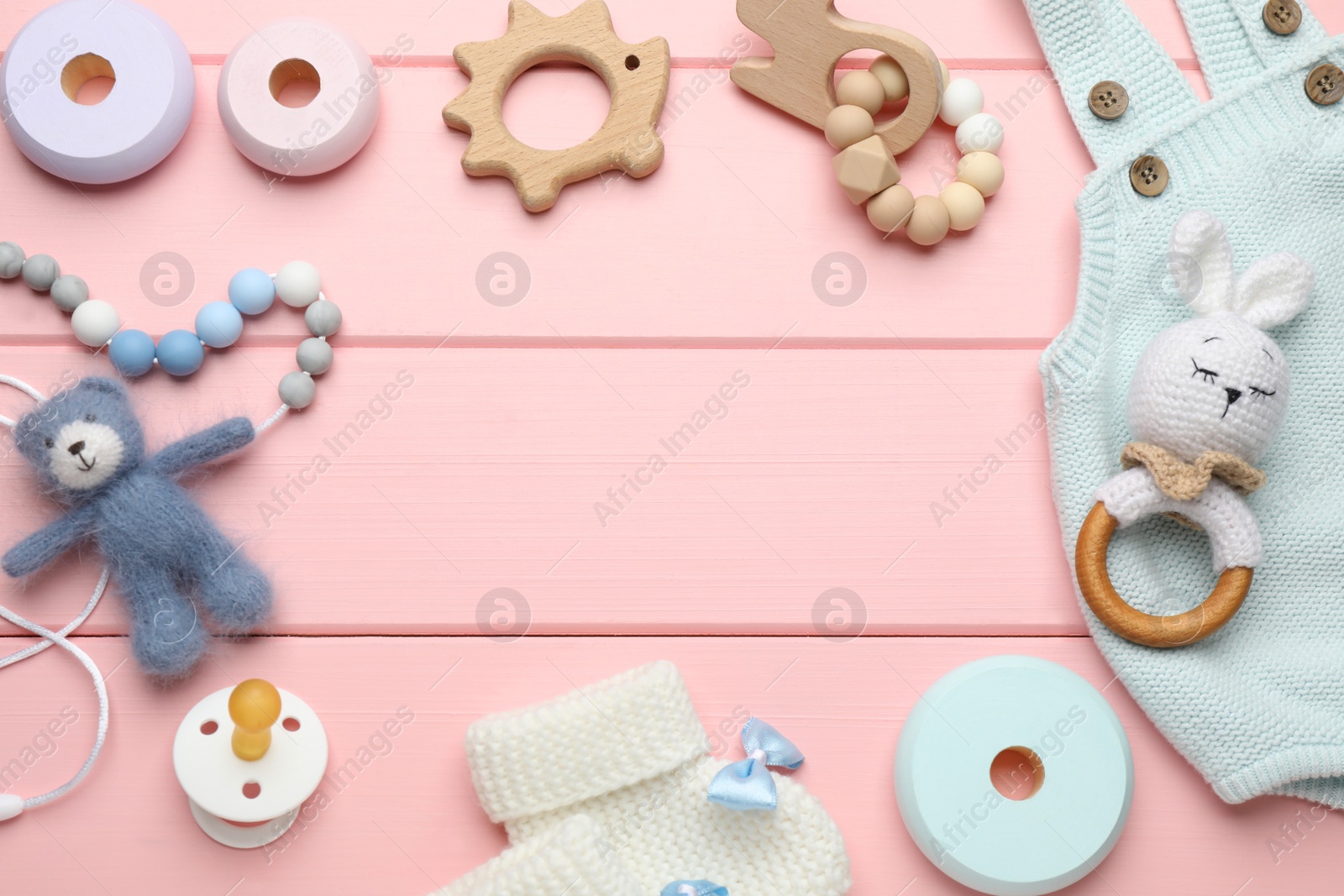 Photo of Cute baby stuff on pink wooden background, flat lay. Space for text