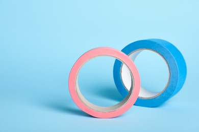 Photo of Two bright rolls of adhesive tape on light blue background
