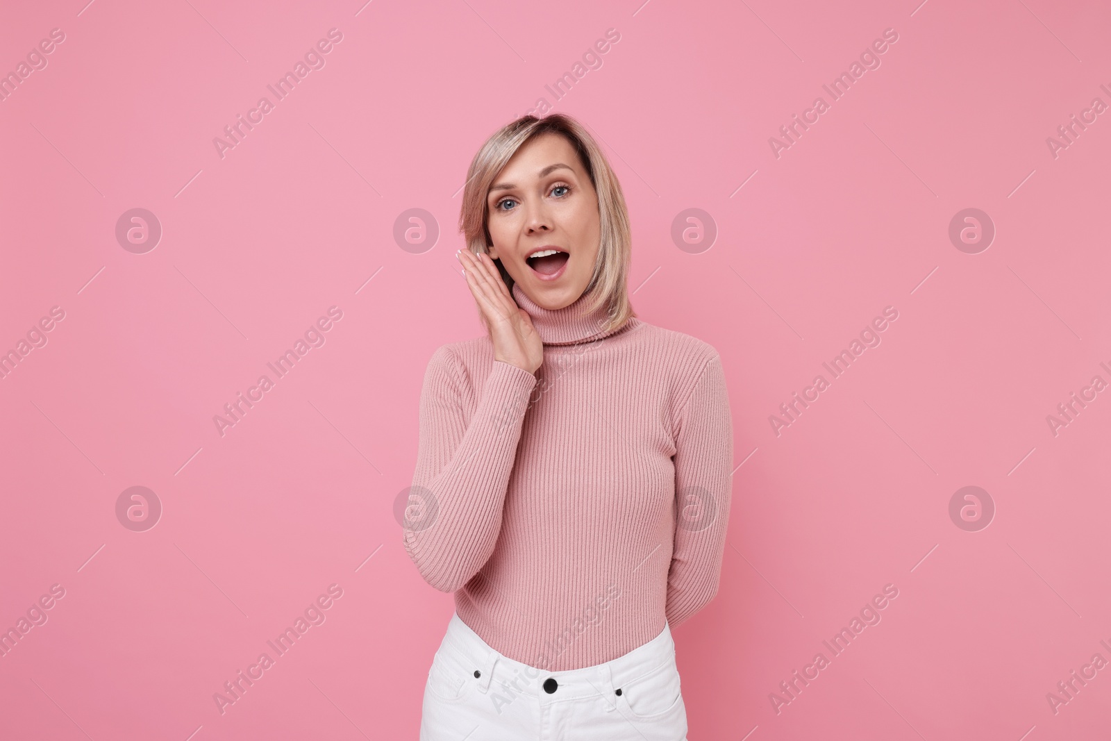 Photo of Beautiful emotional woman posing on pink background