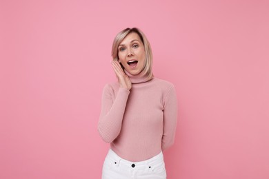 Beautiful emotional woman posing on pink background