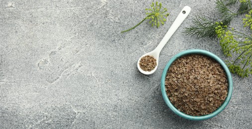 Image of Dill seeds in spoon and bowl on grey table, flat lay. Banner design with space for text