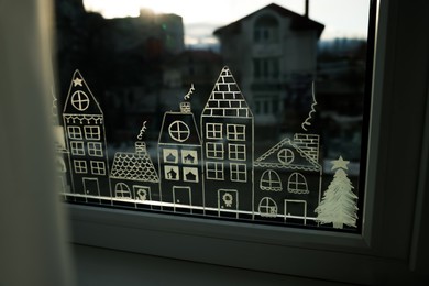 Beautiful drawing made with artificial snow on window. Christmas decor