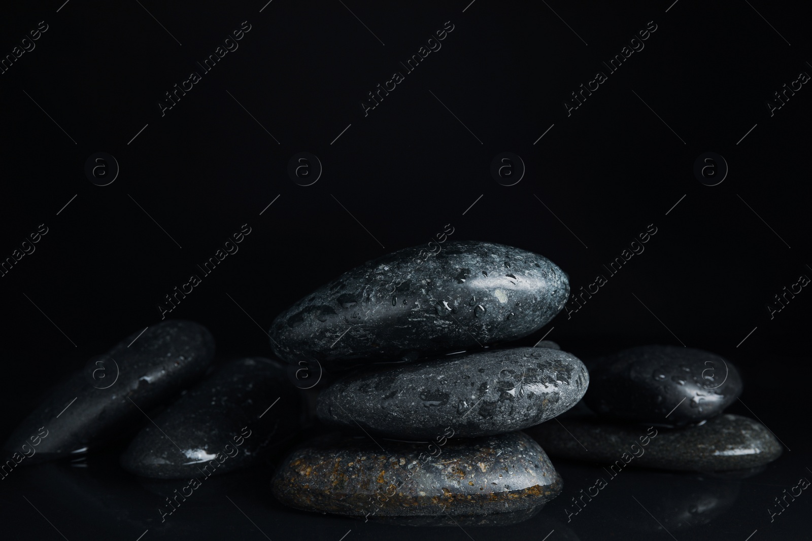 Photo of Stones in water on black background. Zen lifestyle