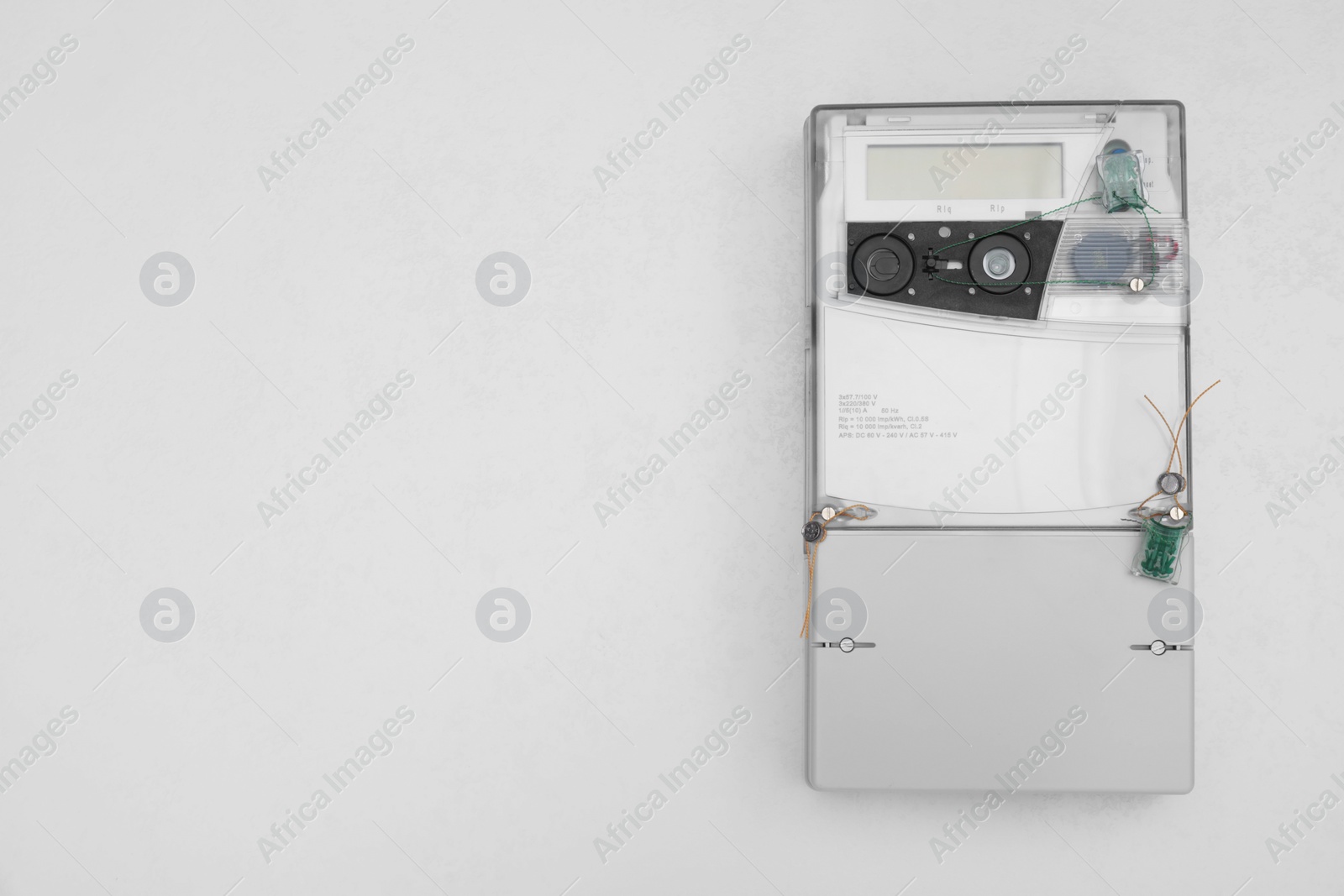 Photo of Electric meter on white background, top view with space for text. Measuring device