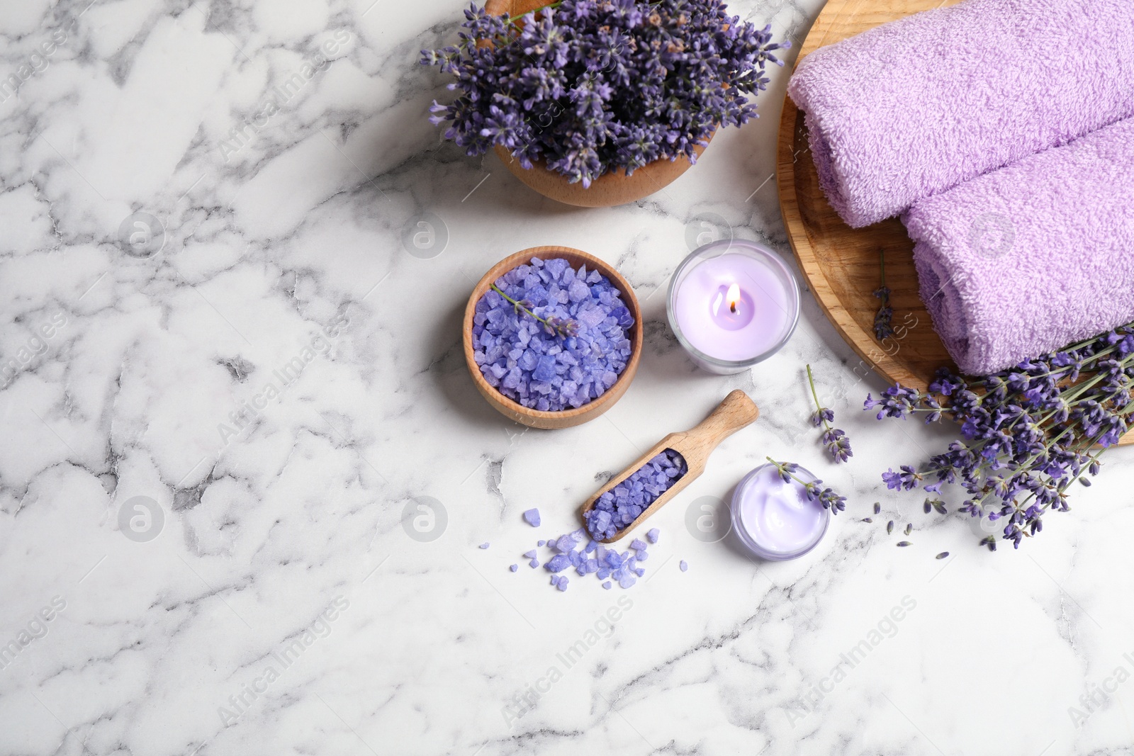 Photo of Cosmetic products and lavender flowers on white marble table, flat lay. Space for text