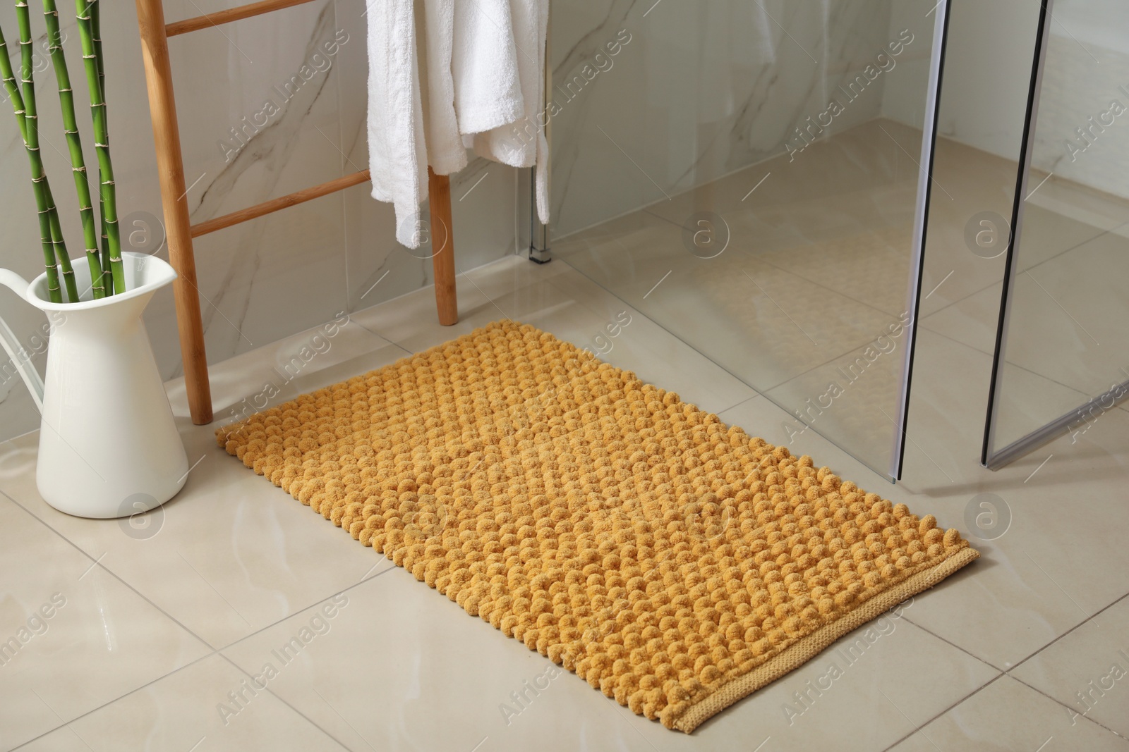 Photo of Soft orange bath mat on floor indoors