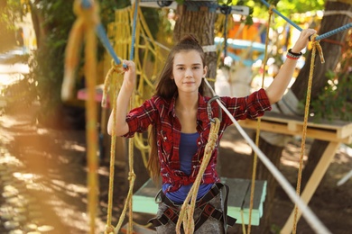 Teenage girl climbing in adventure park. Summer camp