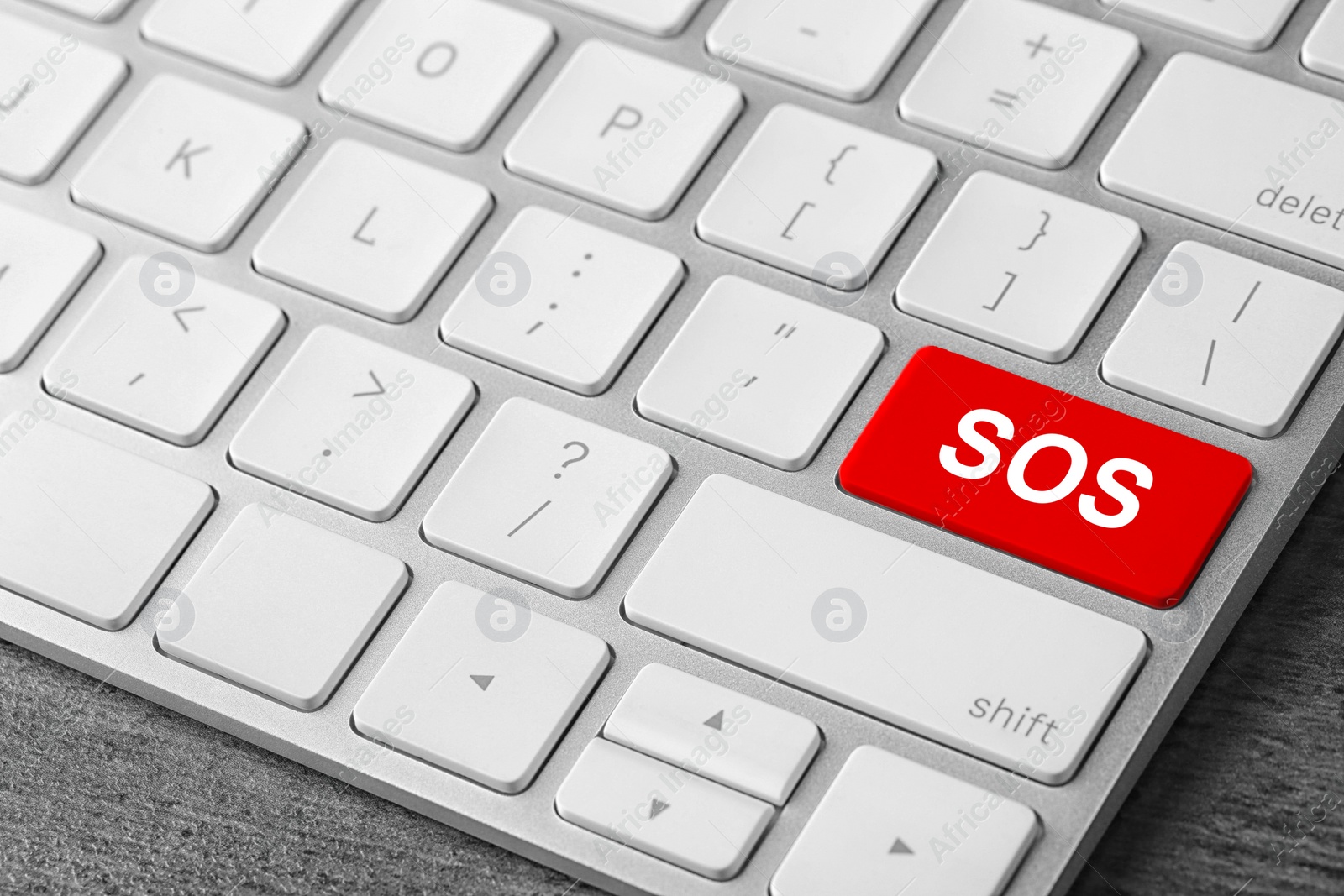 Image of Red button with word SOS on computer keyboard, closeup. Rescue concept