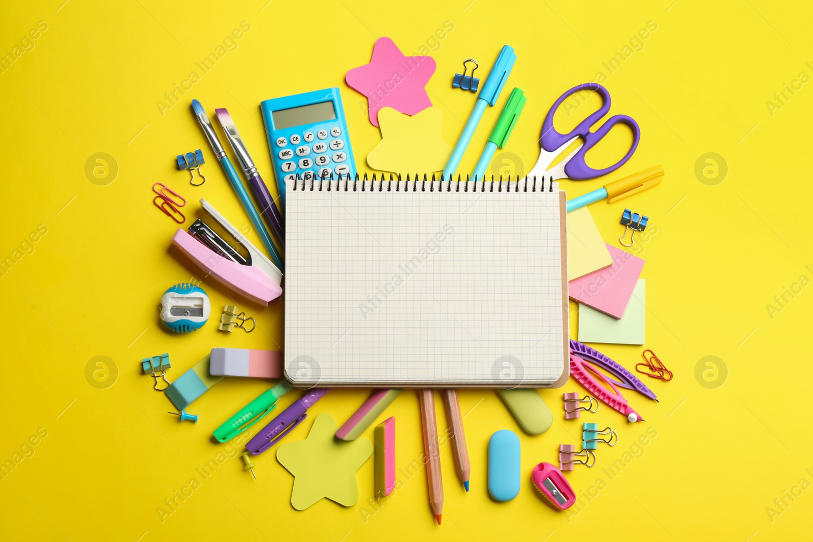 Photo of Blank notebook and school stationery on yellow background, flat lay with space for text. Back to school