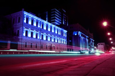 Image of City street with neon lights and car traffic, blur motion effect. Modern metropolis