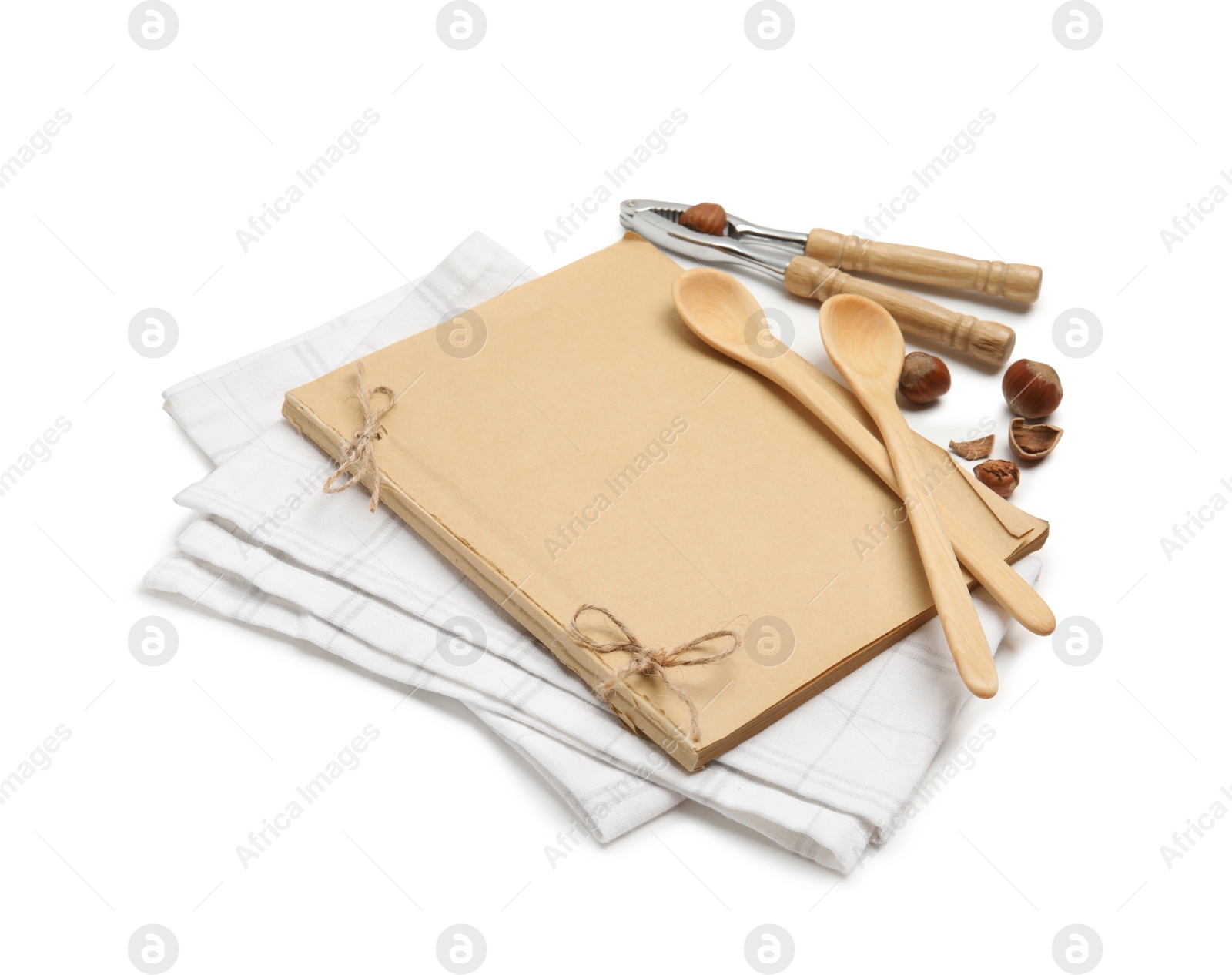 Photo of Blank recipe book, napkin, nuts and wooden utensils on white background. Space for text