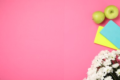 Photo of White chrysanthemum flowers, notebooks and apples on pink background, flat lay with space for text. Teacher's day