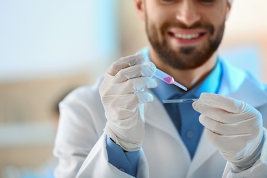 Young scientist working with fluid sample, closeup. Laboratory analysis