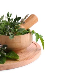 Photo of Wooden board and mortar with different herbs, flowers and pestle on white background