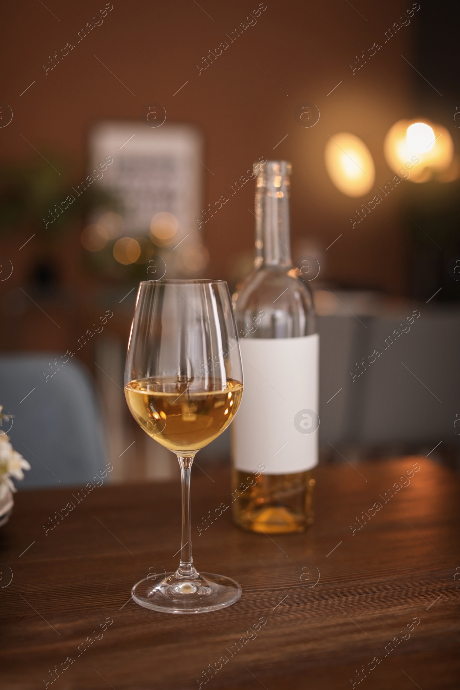 Photo of Glass and bottle of wine on table in restaurant