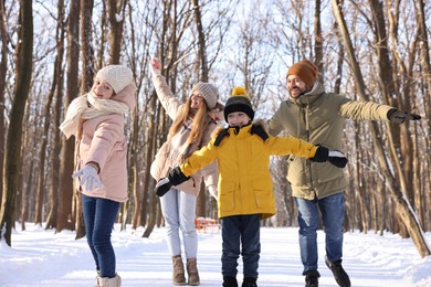 Photo of Happy family having fun in snowy forest