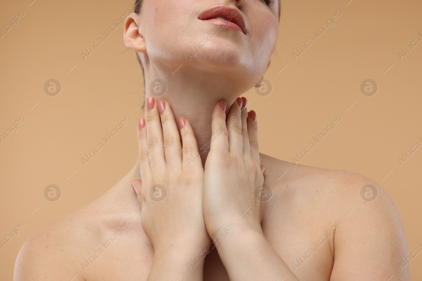 Photo of Woman touching her neck on beige background, closeup