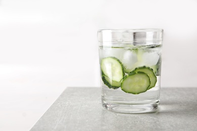Photo of Glass of fresh cucumber water on table. Space for text