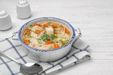 Photo of Dish with fresh homemade chicken soup served on wooden table, space for text