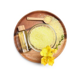 Yellow sea salt in bowl, flowers, cosmetic product and spoon isolated on white, top view