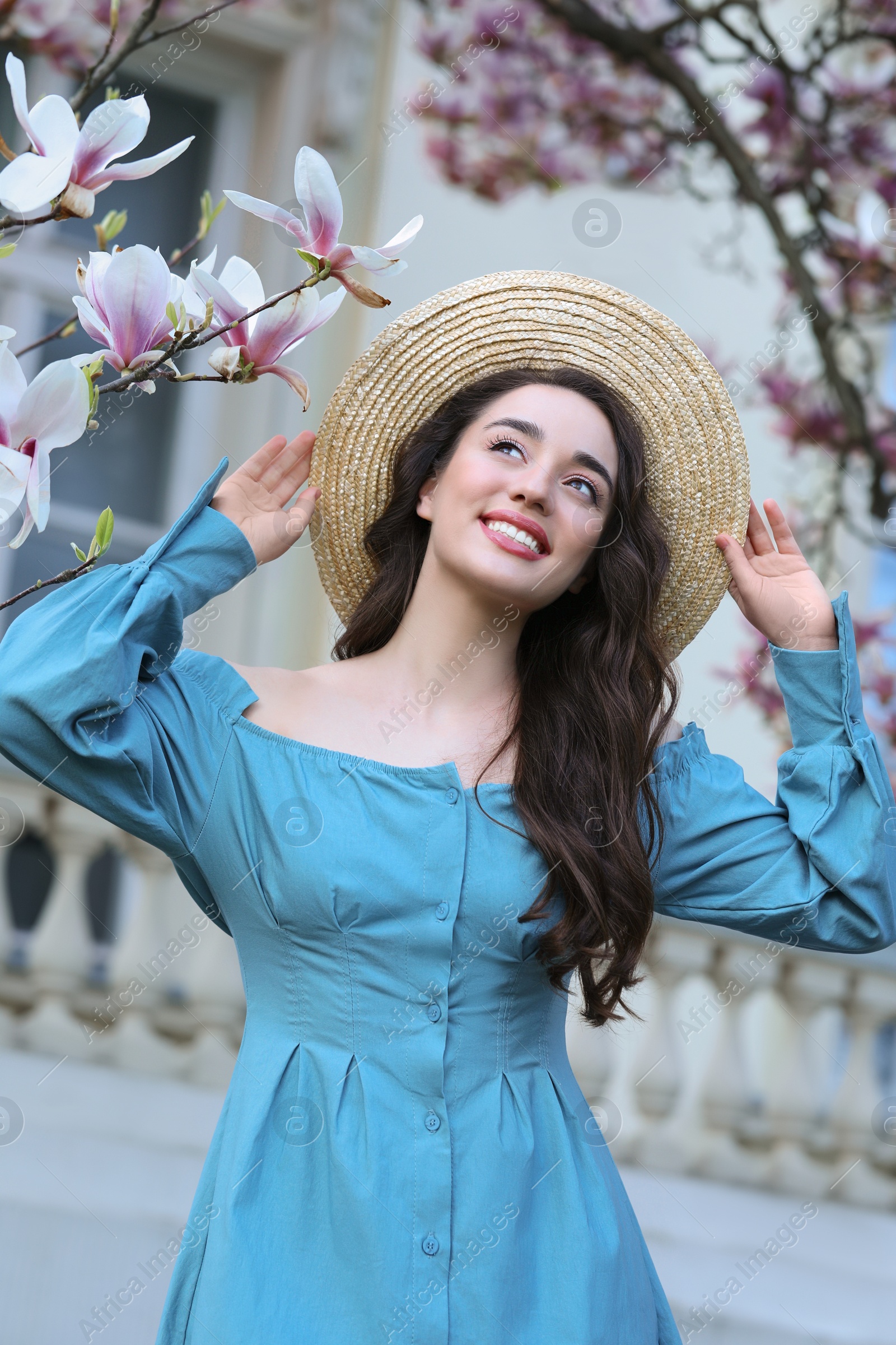 Photo of Beautiful woman near blossoming magnolia tree on spring day