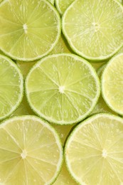 Fresh juicy lime slices as background, top view