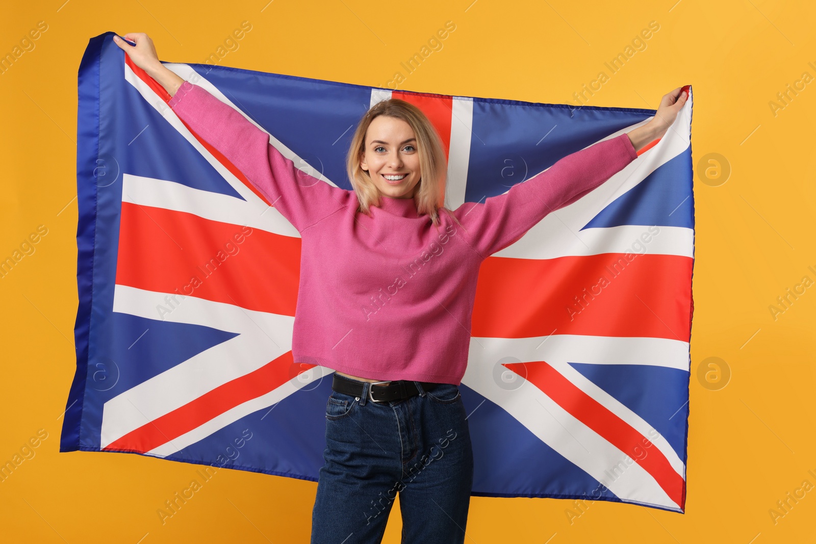 Photo of Happy woman with flag of United Kingdom on orange background