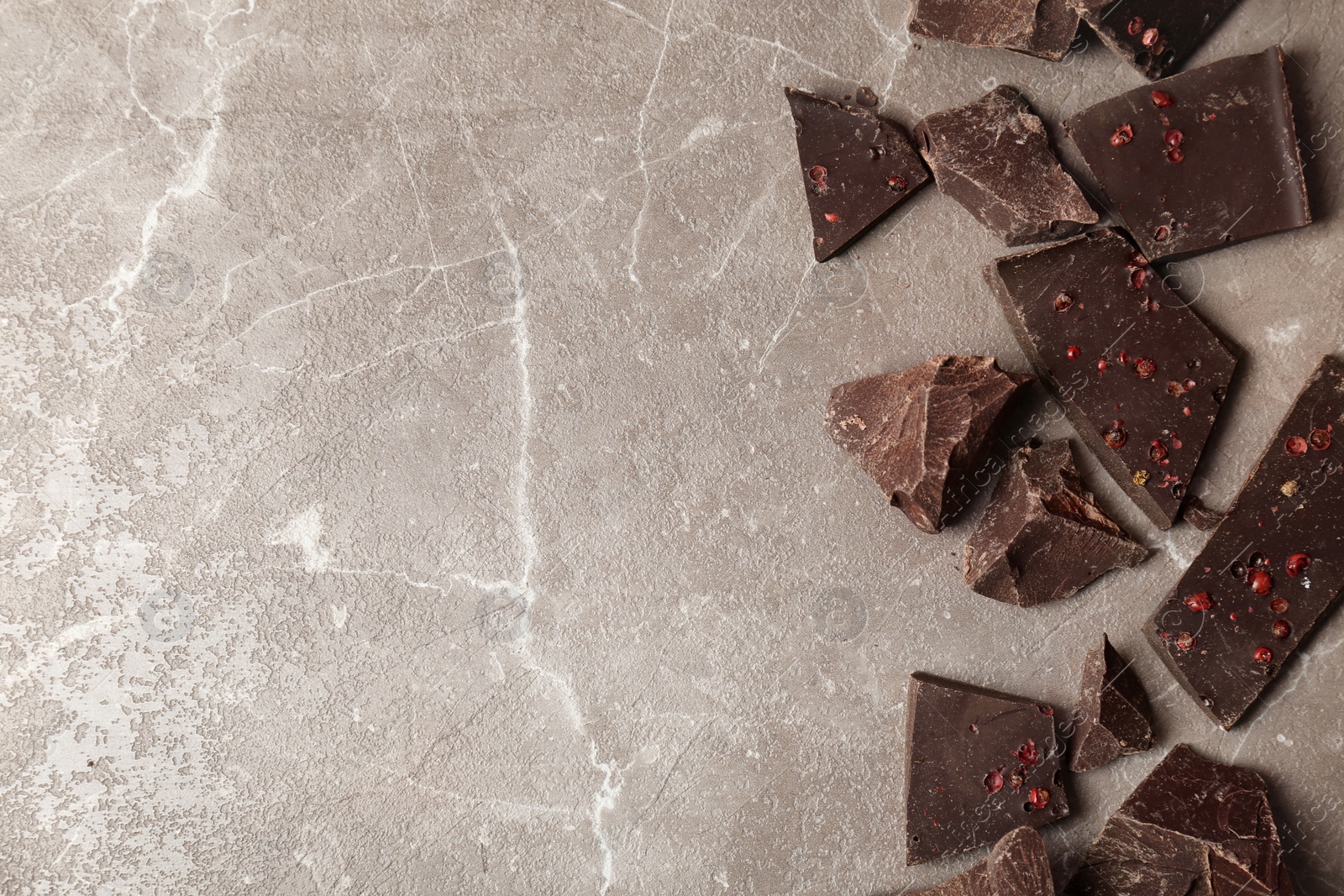 Photo of Pieces of delicious dark chocolate on table, top view